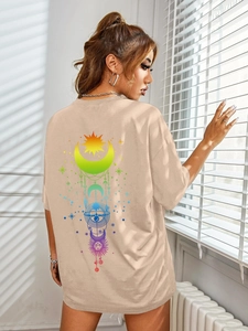 Detail view of rainbow sun and moon mystic print on back of apricot oversized t-shirt