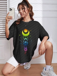 Detail eines bunten mystischen Sonnen- und Mond-Grafikdrucks auf schwarzem Oversize-T-Shirt