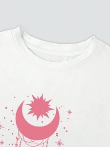 Détail d'un t-shirt en coton blanc avec motif de lune et d'étoiles rose bohème