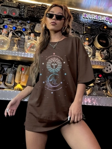 Detailed macro view of sun and moon graphic print on oversized dark brown cotton t-shirt