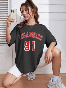 Detail of oversized black cotton T-shirt featuring red Los Angeles 91 athletic print