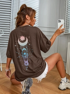 Detail of the oversized dark brown T-shirt back featuring a colorful celestial print