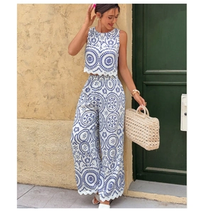 Close-up of blue and white geometric embroidery on women's sleeveless crop top and wide-leg pants