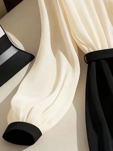 Robe chemise élégante à manches longues bicolore beige et noir avec détails plissés