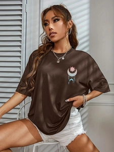 Close-up of coffee brown loose T-shirt featuring sun and moon graphic print