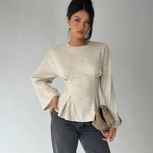 Women's chic long sleeve flare top in light beige paired with dark grey jeans