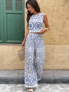 Detail of scalloped hem on floral sleeveless crop top and high-waist wide-leg pants