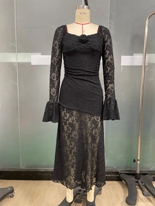 Detail of black lace dress featuring 3D rose neckline and elegant flared sleeves