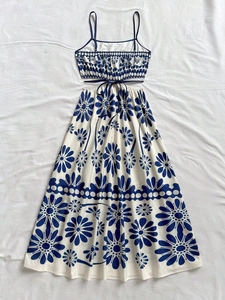 Detail of backless summer dress with blue daisy patterns and stylish waist cut-out