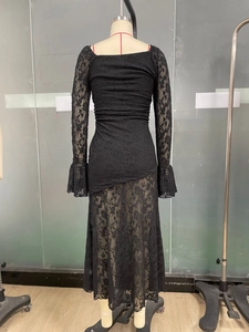 Detailed back view of a black lace dress featuring ruched fabric and sheer floral hem