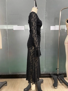 Detailed view of black lace long-sleeved dress with sheer floral embroidery and pleats