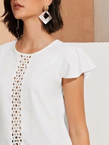 Detailed close-up of white summer blouse with elegant eyelet lace and flutter sleeves