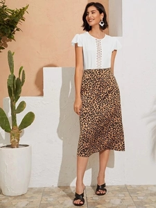 Close-up of white chiffon top with hollow lace eyelets and leopard print midi skirt