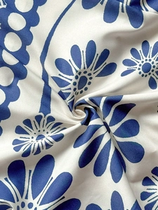 Macro shot of silk-textured fabric showing blue floral prints and soft elegant folds