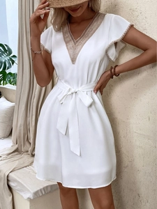 Elegant white V-neck mini dress with lace patchwork, flutter sleeves, and waist tie