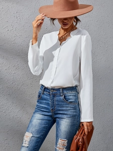 Detail of white long sleeve blouse with ruffled notch collar and button front detail