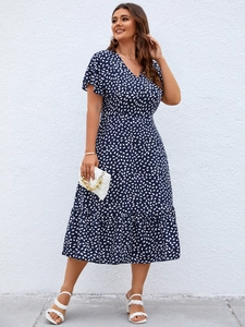 Detail of plus size navy blue V-neck dress with white polka dots and ruffle hem