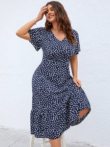 Detail of V-neck short sleeve dark blue dress with white dots and ruffled hemline