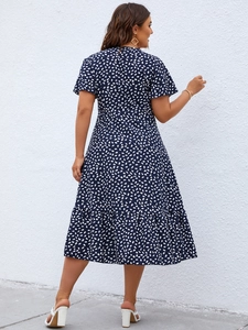 Detail view of navy floral midi dress featuring ruffled hem and elegant waist silhouette