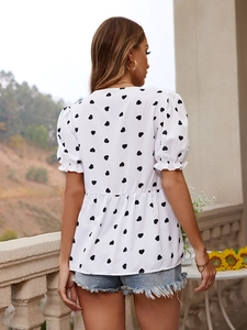 Back view of a white heart-print bubble sleeve top with ruffled cuffs and elastic hem