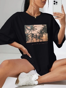 Black oversized T-shirt for women featuring palm tree sunset print and crew neck