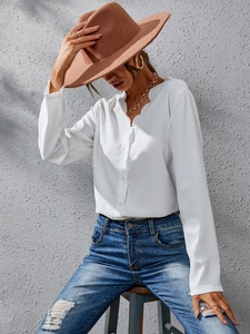 Elegant white long sleeve V-neck blouse with ruffled edges paired with casual jeans