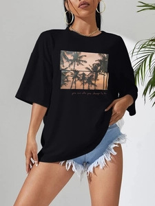 Detail of black cotton T-shirt featuring palm tree sunset print and red script text