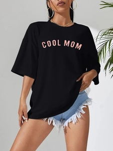 Gros plan sur un T-shirt noir oversize avec impression de lettres roses COOL MOM
