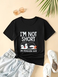 Mise à plat d'un t-shirt pingouin noir avec un short en jean et des baskets blanches