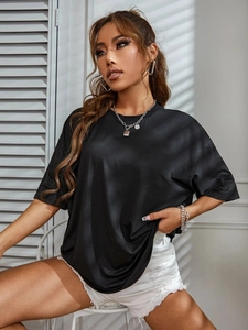 Gros plan d'un t-shirt en coton noir ample avec des effets d'ombres rayées chic