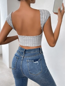 Détail du dos d'un crop top gris en maille côtelée avec un design dos nu sexy et ajusté