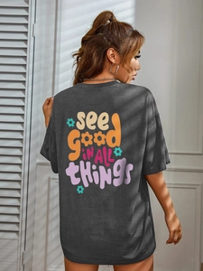 Détail de l'imprimé coloré au dos d'un t-shirt gris foncé ample avec citation inspirante