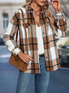 Detail of plaid shacket featuring flap chest pockets and classic button-down front