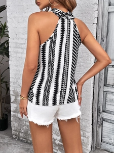 Detail of a women's halter top featuring black and white geometric patterns and back zipper