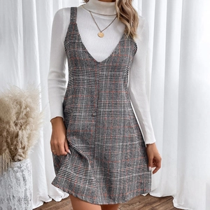 Detail of grey plaid V-neck strap dress with white ribbed turtleneck and gold necklace