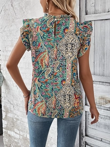 Detail of bohemian paisley print top featuring ruffled neckline and back keyhole closure