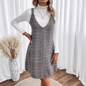 Women's V-neck plaid sleeveless dress layered over a white long sleeve turtleneck sweater