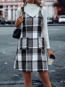 Detailaufnahme des karierten Trägerkleids mit zwei Fronttaschen und urbanem Streetstyle-Look