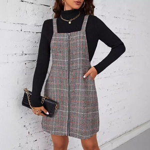 Robe à carreaux grise avec fermeture éclair et poches portée sur un col roulé noir