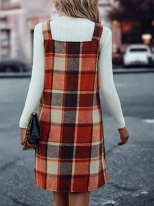 Straßenansicht von hinten: Model trägt ein kariertes Trägerkleid mit weißem Rollkragen