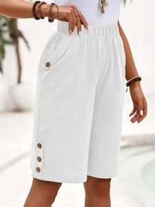 Detail of high-waisted white linen shorts with elastic waist and side button accents