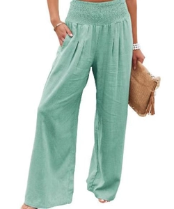 Detail of high waisted wide leg trousers in mint green with smocked elastic waistband