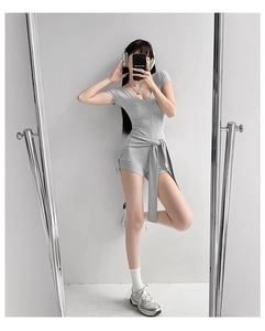 Détail d'un combishort de yoga gris à manches courtes avec lien à nouer à la taille
