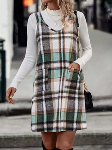 Nahaufnahme des karierten Trägerkleids in Grün und Braun mit Tweed-Struktur und Taschen