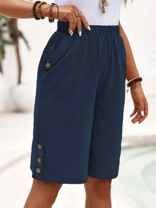 Detail showing navy blue cotton linen high-waisted shorts with decorative buttons