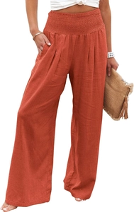 Detail of high waisted wide leg trousers in deep orange featuring elastic pleated waistband