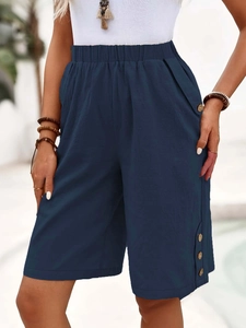 Detail of dark blue linen shorts featuring vintage wooden buttons and high-waist elastic band