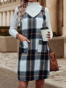 Detail des karierten Trägerkleids mit quadratischen Taschen und britischem Retro-Stil