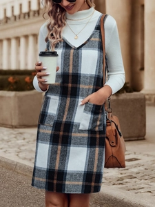 Detail eines karierten Trägerkleids mit zwei Vordertaschen und elegantem Streetstyle-Look