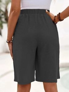 Back view of dark gray high-waisted cotton linen wide-leg shorts on a female model